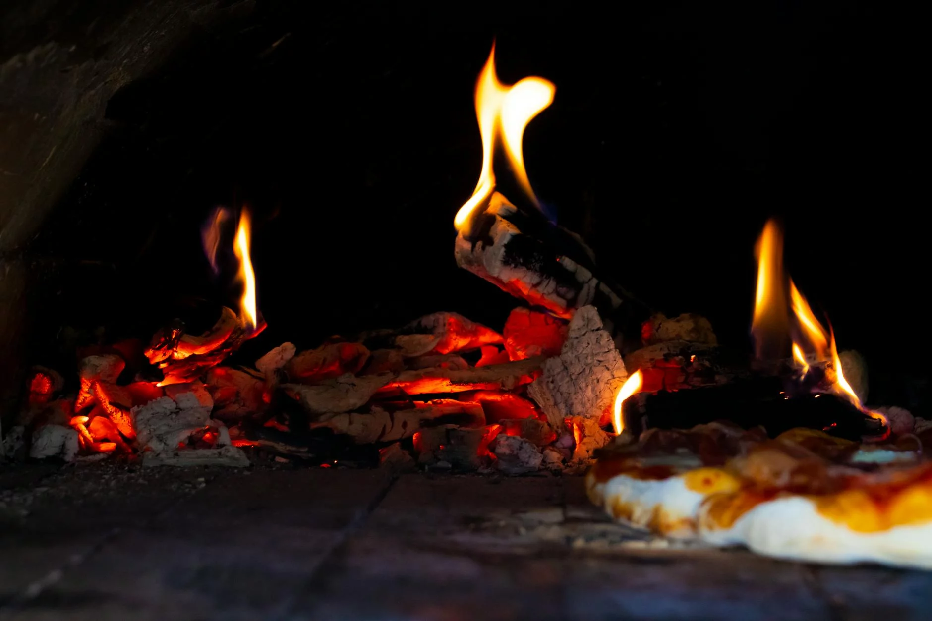 coal fired pizza oven with flames